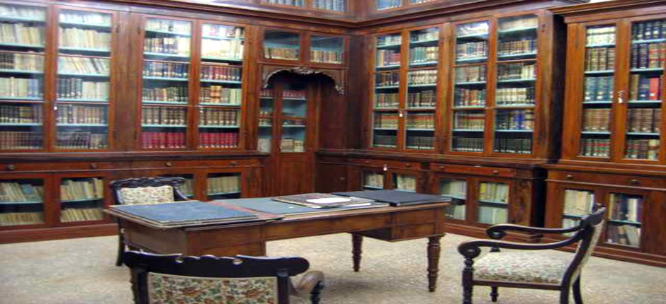 Immagine della bibioteca storica con tavolino antico e volumi